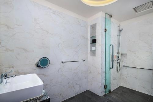 a bathroom with a glass shower and a sink at Le Méridien Kuala Lumpur in Kuala Lumpur