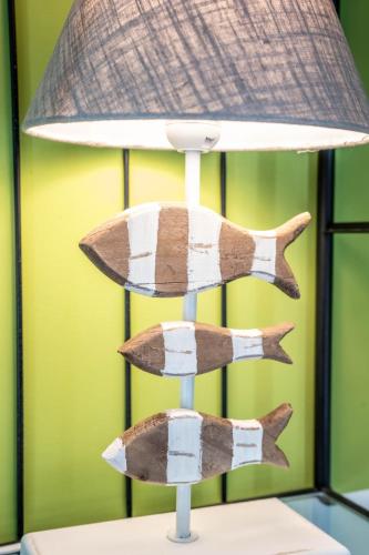a lamp with three wooden fish on a table at Pension Spreewelten in Lübbenau