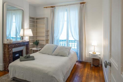 - une chambre avec un lit, une cheminée et deux fenêtres dans l'établissement 4 Guests Apt Jardin des Plantes, à Paris
