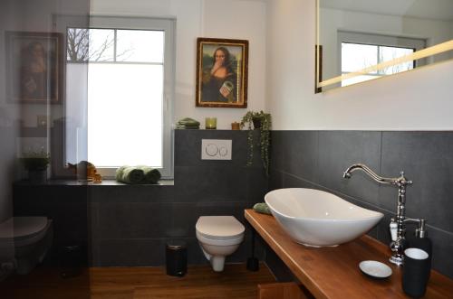 ドルム・ノイフェルトにあるDeichkiekerの白い洗面台とトイレのあるバスルーム