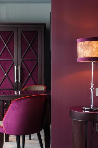 a purple room with a table and a lamp at Malmaison Aberdeen in Aberdeen