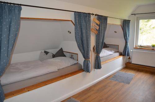 ドルム・ノイフェルトにあるDeichkiekerのベッドとカーテンのついた窓のある寝室