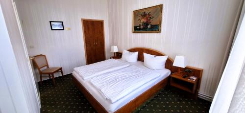 a hotel room with a bed and a chair at Hotel Meereswelle - Anno 1875 in Ahlbeck