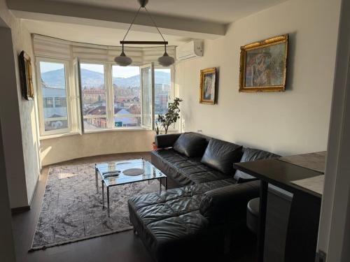 een woonkamer met een bank en een tafel bij SleepInNP in Novi Pazar