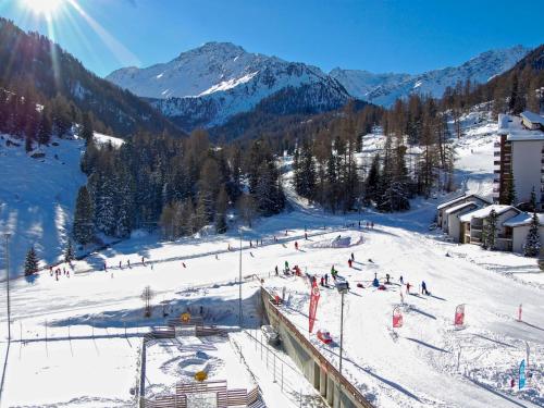 a group of people skiing down a snow covered slope at Apartment Rosablanche-108 by Interhome in Siviez