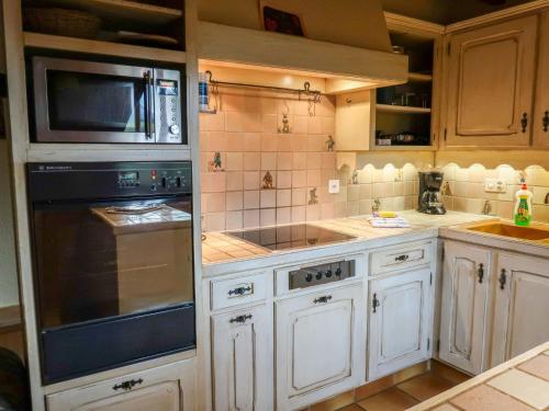 a kitchen with a microwave and a stove top oven at Chalet Chalet le Chamois by Interhome in Moleson