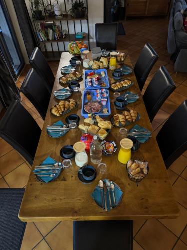 une longue table en bois avec de la nourriture dessus dans l'établissement Parc de la Charmille, à Saint-Étienne-sur-Reyssouze