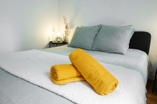- un lit avec une serviette jaune au-dessus dans l'établissement Appartement Central Les Halles, à Paris