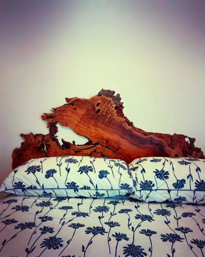 a wooden headboard of a bed with a bedsheet at Porto Antico in Bari