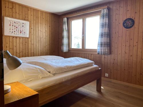 a bedroom with a bed and a window in it at Chalet Chalet Soldanella - BEL205 by Interhome in Bellwald