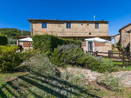 a stone building with umbrellas in front of it at Apartment La Vigna by Interhome in Lucolena in Chianti