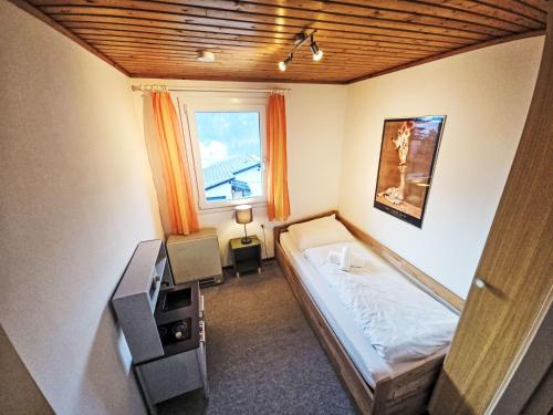 a small bedroom with a bed and a window at Apartment Crap Grisch by Interhome in Ruschein