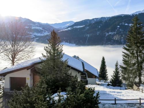 a house in the snow with a view of the mountains at Apartment Crap Grisch by Interhome in Ruschein