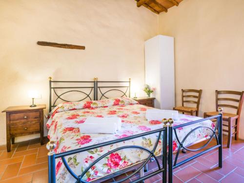a bedroom with a bed with a floral bedspread at Apartment Laura by Interhome in Lucolena in Chianti