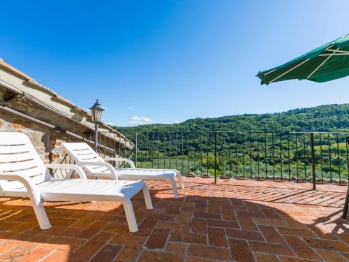 a group of white chairs sitting on a brick patio at Apartment Laura by Interhome in Lucolena in Chianti