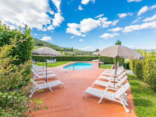 a row of lawn chairs with umbrellas next to a pool at Holiday Home Olivo by Interhome in Lucolena in Chianti