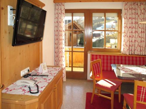 卡普尔Apartment Apart Garni Royal-1 by Interhome的厨房设有墙上的电视和柜台。