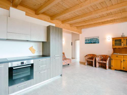 a kitchen with stainless steel appliances and wooden ceilings at Apartment Ciampedie by Interhome in Pera