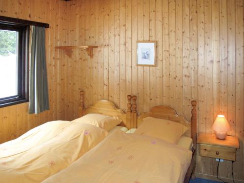 Saas-BalenにあるHoliday Home Edelweiss-1 by Interhomeの木製パネルの壁の部屋にベッドが2つある