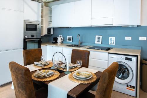 une cuisine avec une table et des chaises ainsi qu'un lave-linge. dans l'établissement Appartement de Charme à Montorgueil, à Paris