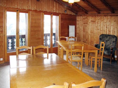 a dining room with wooden tables and chairs and windows at Chalet Chalet Anthamatten-3 by Interhome in Champéry