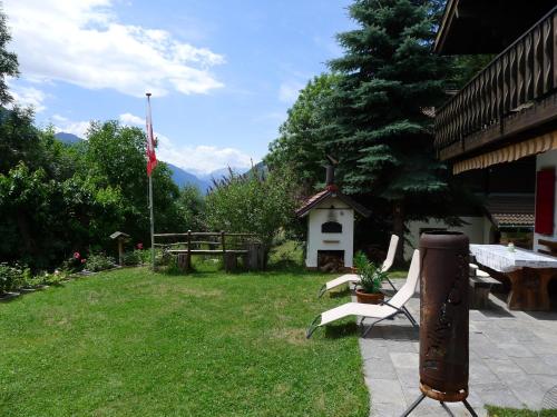 a yard with a table and chairs and a grill at Chalet Chalet Walliserträumli - BET410 by Interhome in Grengiols