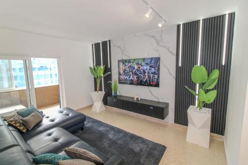 un soggiorno con divano e TV a schermo piatto di Designer - 60 Seconds to the Beach I Free Parking! a San Giuliano