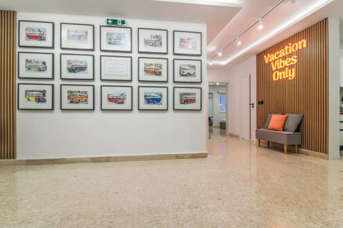 a lobby with a white wall with pictures on it at Designer - 60 Seconds to the Beach I Free Parking! in St Julian's