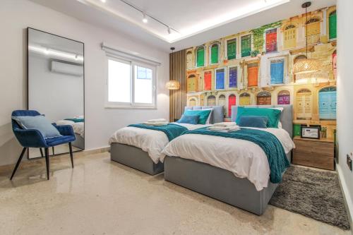 a bedroom with two beds and a wall with colorful pictures at Designer - 60 Seconds to the Beach I Free Parking! in St Julian's