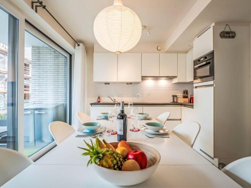 eine weiße Küche mit einem Tisch und einer Schale Obst in der Unterkunft Apartment Heritage by Interhome in Bredene