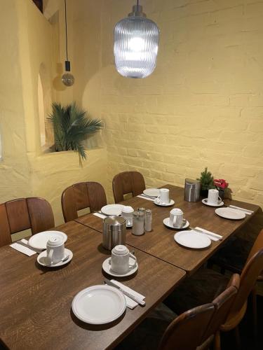 a wooden table with white plates and napkins on it at Hotel Elsen in Grevenbroich