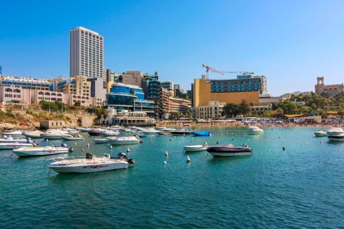 a group of boats in the water in a city at Designer - 60 Seconds to the Beach I Free Parking! in St Julian's