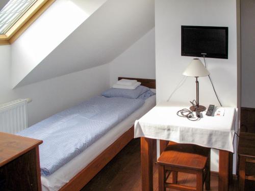 a bedroom with a bed with a table and a tv at Holiday Home Holetín by Interhome in Horní Holetín