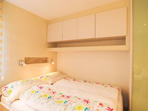 a bed with flowers on it in a room at Studio Cristal 36 by Interhome in Leukerbad