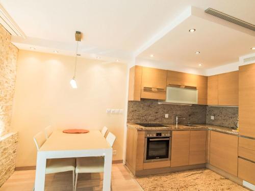 a kitchen with a white table and a white stool at Apartment Cristal-4 by Interhome in Leukerbad
