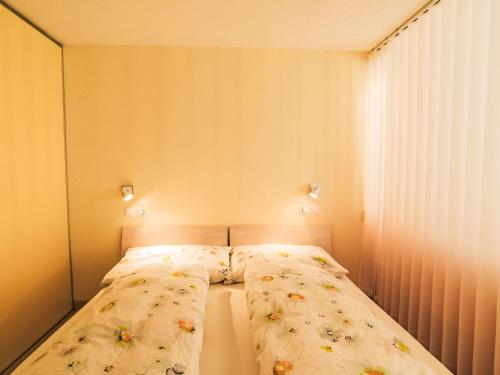 a small bedroom with a bed with flowers on it at Apartment Cristal-4 by Interhome in Leukerbad