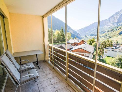 a balcony with a desk and chair and a view of mountains at Apartment Cristal-6 by Interhome in Leukerbad
