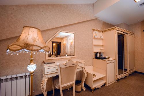 a room with a desk and a mirror and a lamp at Baku Hotel Ganja in Ganja