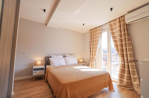 une chambre avec un lit et une grande fenêtre dans l'établissement AzurAppart Brilliant 2room, Nice Massena, à Nice