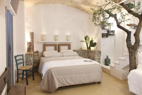 a bedroom with two beds and a tree in it at La Vitagira in Monopoli