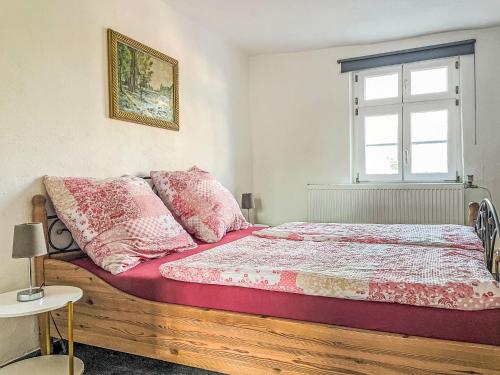 Un dormitorio con una cama con almohadas rosas y una ventana. en Apartment Therese by Interhome, en Mirow