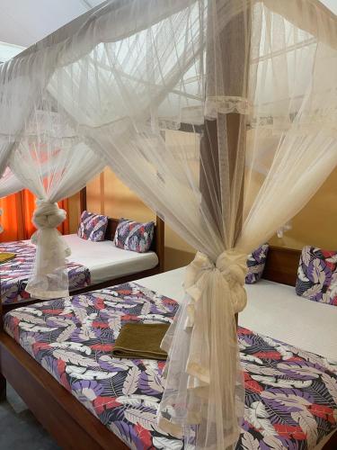 a bedroom with two beds with mosquito nets at Vitamin sea beach cabana in Nilaveli