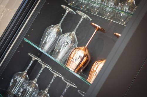 a display case with glass wine glasses on shelves at Greta s Hüs in Archsum