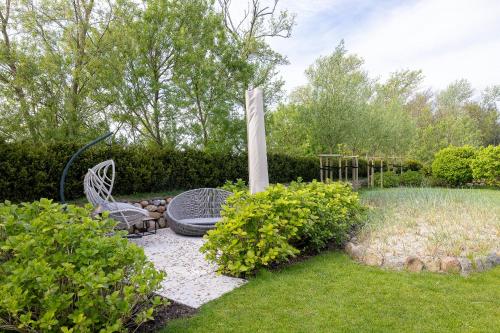 a garden with two chairs and a monument at Greta s Hüs in Archsum