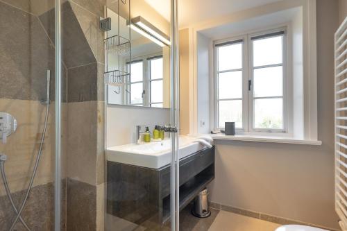a bathroom with a sink and a shower at Greta s Hüs in Archsum