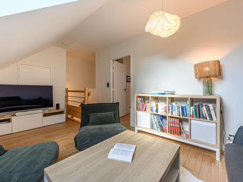 Una sala de estar con un sofá y un televisor. en Holiday Home Le Spi by Interhome, en La Trinité-sur-Mer
