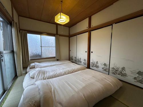 three beds in a room with a window at SSK Mountain Base in Tsumagoi