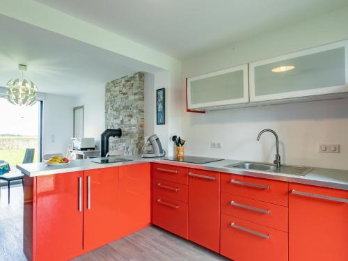 une cuisine avec des armoires rouges et un évier dans l'établissement Holiday Home Le Nid Marin by Interhome, à Kerlouan