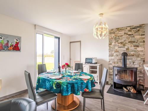 une salle à manger avec une table et des chaises et une cheminée dans l'établissement Holiday Home Le Nid Marin by Interhome, à Kerlouan