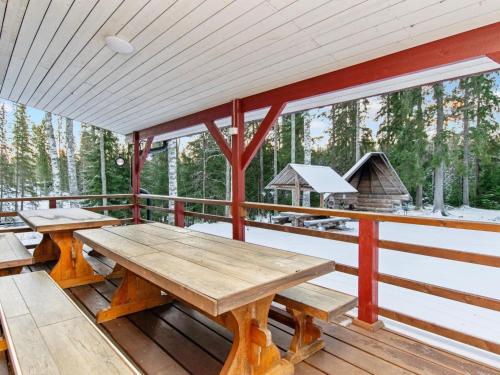 un portico con due tavoli da picnic e una griglia di Holiday Home Jauli by Interhome a Latovesi